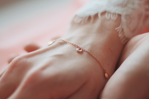 closeup-shot-female-wearing-fashionable-bracelet-with-charm-pendants_181624-21048